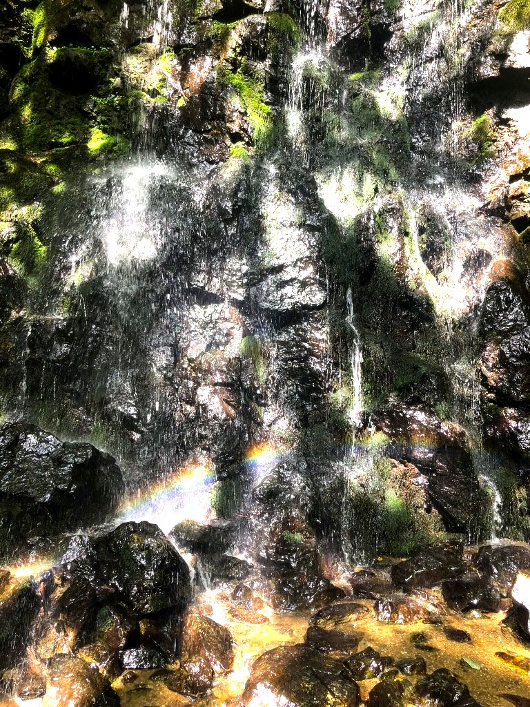 Cascata di Slap Skalca con arcobaleno sulle rocce coperte di muschio, Slovenia