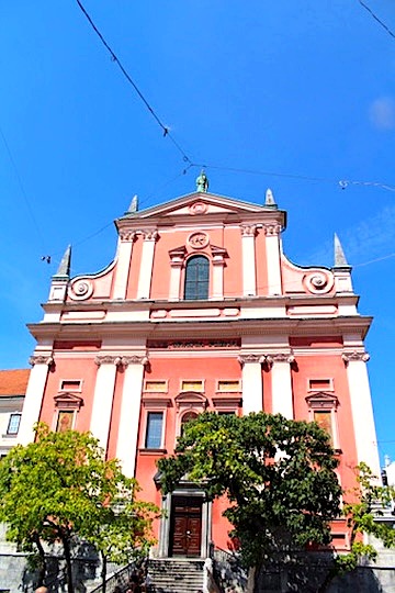Facciata rosa della chiesa francescana sulla piazza Prešernov trg a Lubiana