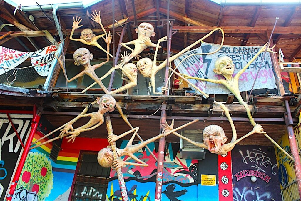 Sculture artistiche sospese sulla facciata di un edificio nel quartiere di Metelkova, Lubiana