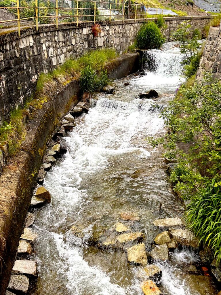 Torrente che scorre tra i muretti in pietra nel centro di Aprica