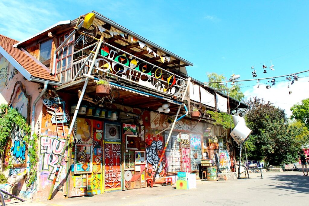 Facciata colorata con bandierine e scarpe appese a un filo, quartiere Metelkova