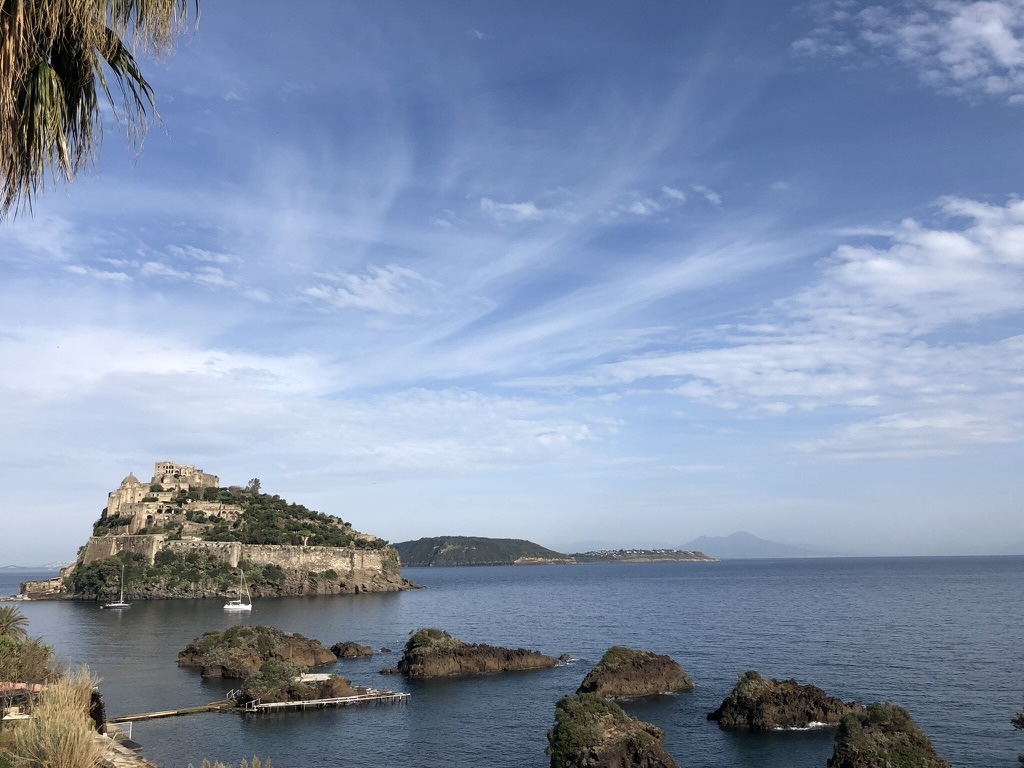 Il Castello Aragonese di Ischia visto dal mare, con isolotti rocciosi in primo piano