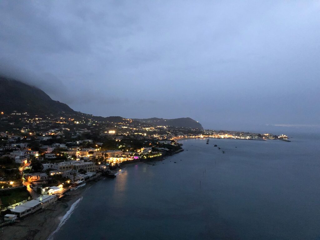 Costa di Forio illuminata al crepuscolo, vista dall'alto verso il mare